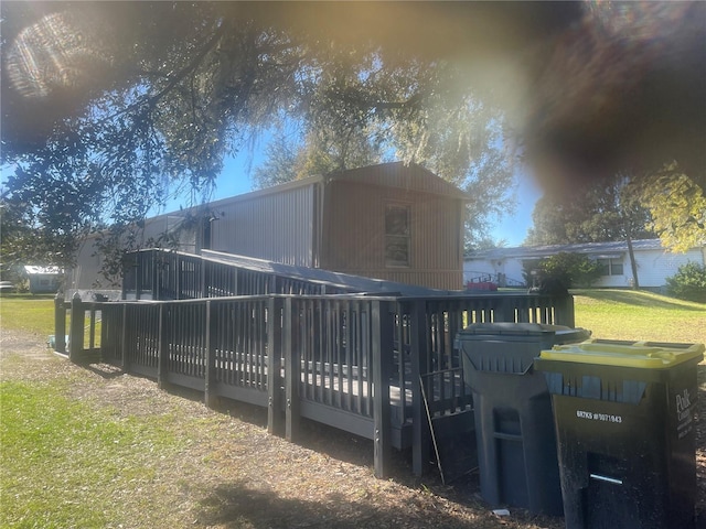 rear view of house featuring a deck and a lawn