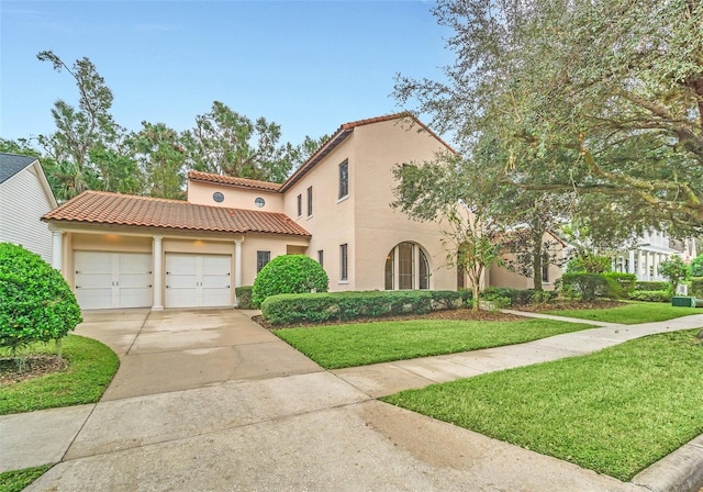 mediterranean / spanish-style home with a garage and a front lawn