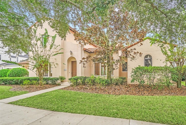 mediterranean / spanish-style house featuring a front lawn