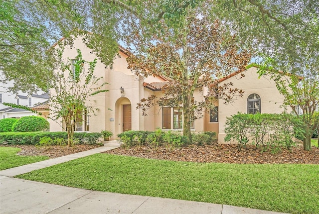 1233 Aquila Loop, Celebration, FL 34747 - mediterranean / spanish-style house with stucco siding, a front lawn, and a tiled roof