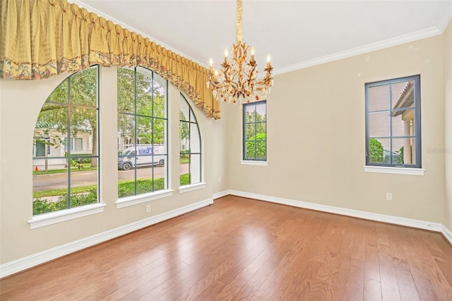 unfurnished room featuring an inviting chandelier, a healthy amount of sunlight, and wood-type flooring