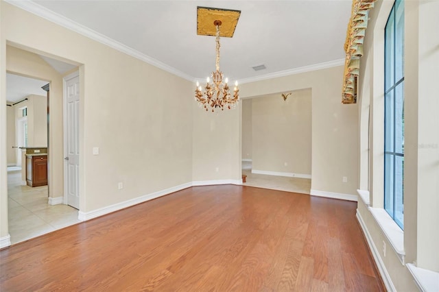 1233 Aquila Loop, Celebration, FL 34747 - spare room with a chandelier, ornamental molding, light wood-style flooring, and baseboards