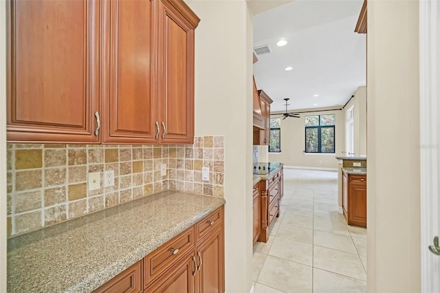 1233 Aquila Loop, Celebration, FL 34747 - kitchen featuring tasteful backsplash, light stone countertops, light tile patterned floors, brown cabinetry, and recessed lighting
