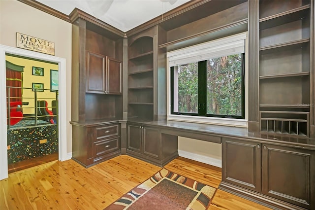 1233 Aquila Loop, Celebration, FL 34747 - unfurnished office with built in study area, light wood-style floors, crown molding, and baseboards