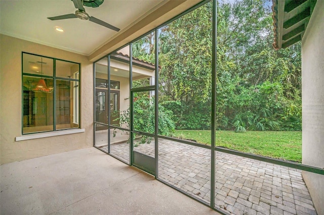 unfurnished sunroom with ceiling fan