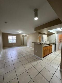 kitchen with sink, light tile patterned floors, and kitchen peninsula