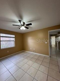 tiled spare room featuring ceiling fan