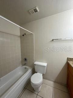 full bathroom featuring tile patterned floors, tiled shower / bath, vanity, and toilet