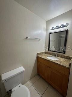 bathroom with tile patterned flooring, vanity, and toilet