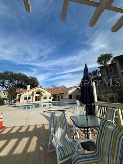 deck with a pergola and a community pool