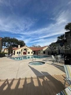 view of pool with a patio and a hot tub