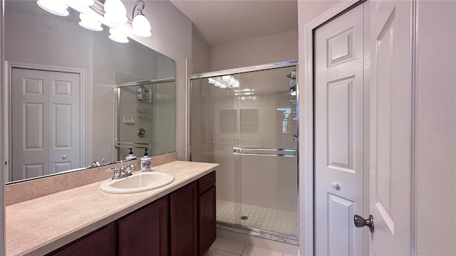 bathroom with tile patterned flooring, vanity, an enclosed shower, and an inviting chandelier