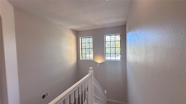 staircase with a textured ceiling