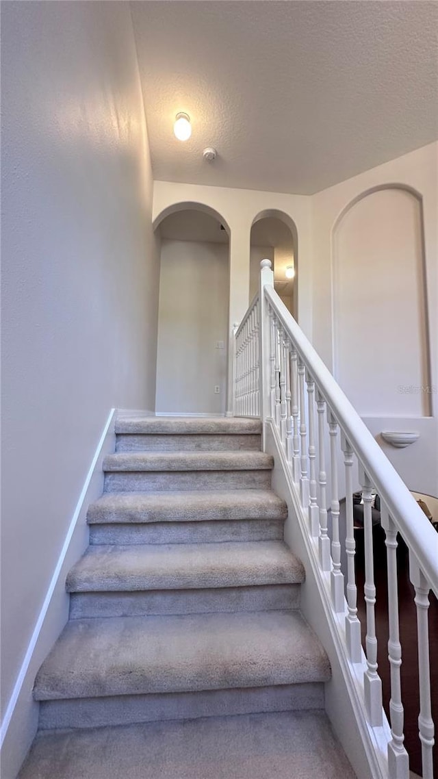 stairway with a textured ceiling