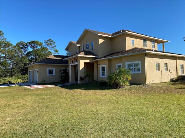 rear view of property featuring a garage and a lawn