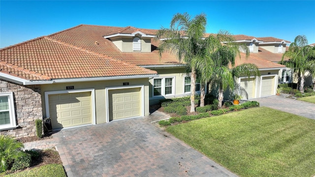 mediterranean / spanish-style house featuring a front yard and a garage