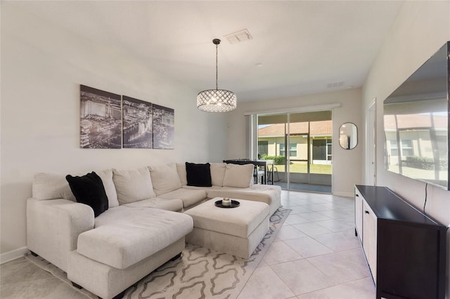 tiled living room featuring plenty of natural light and a notable chandelier