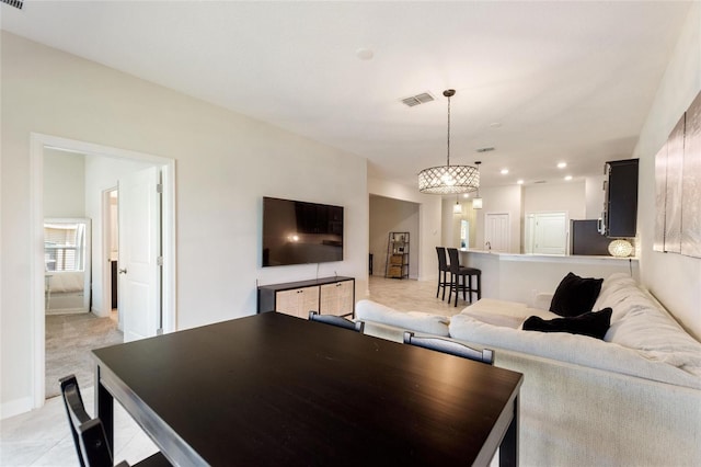 carpeted living room featuring an inviting chandelier