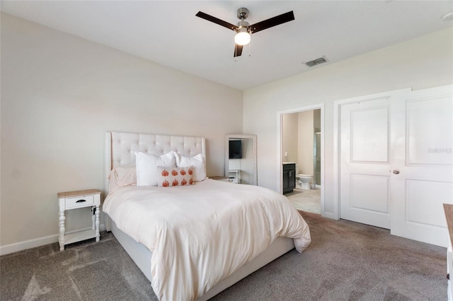 bedroom with dark colored carpet, ceiling fan, and ensuite bath