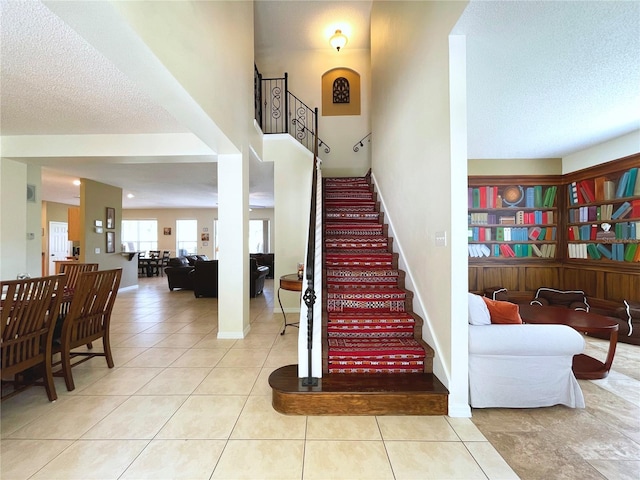 stairs featuring tile patterned flooring and a textured ceiling