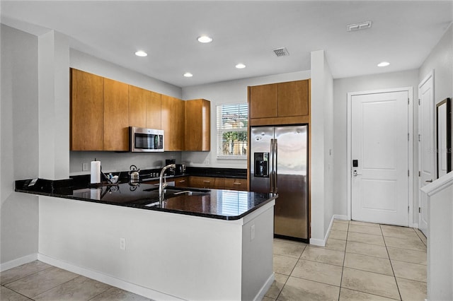 kitchen featuring sink, kitchen peninsula, stainless steel appliances, and light tile patterned floors