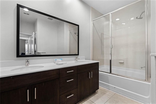 bathroom with tile patterned flooring, vanity, and bath / shower combo with glass door