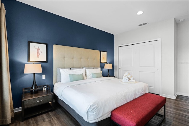 bedroom with dark hardwood / wood-style floors and a closet