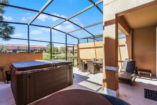 view of patio / terrace featuring a lanai and a hot tub