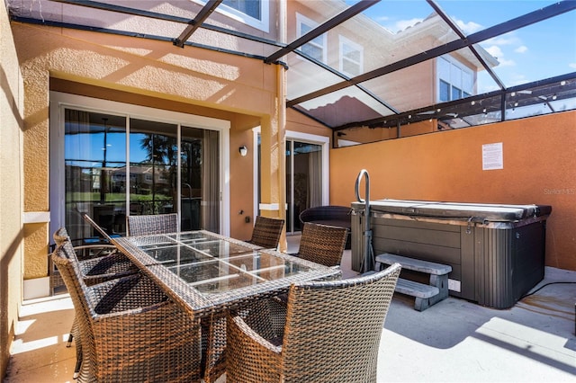 view of patio with glass enclosure and a hot tub