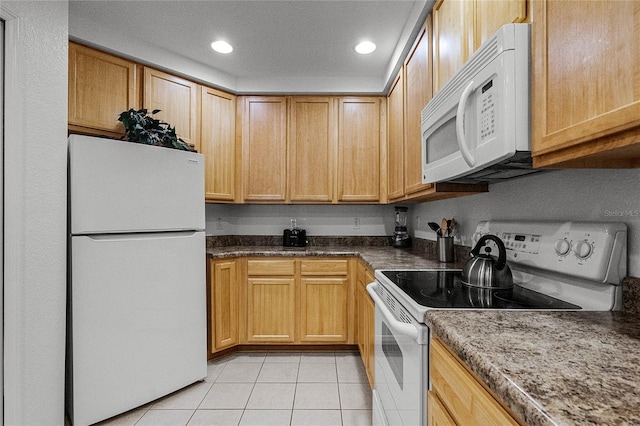 kitchen featuring light tile patterned floors and white appliances