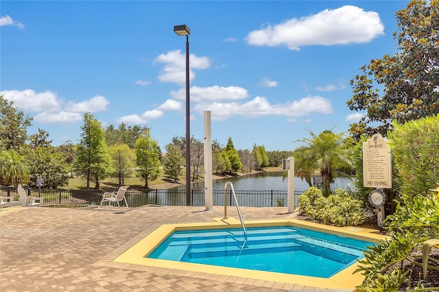 view of swimming pool featuring a patio area, a water view, and a community hot tub