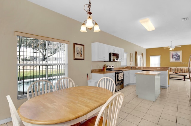 dining room with light tile patterned floors, ceiling fan, a healthy amount of sunlight, and sink