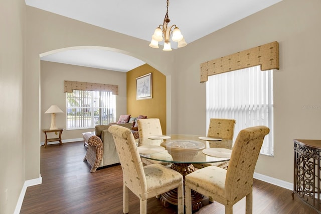 dining room with dark hardwood / wood-style floors and an inviting chandelier