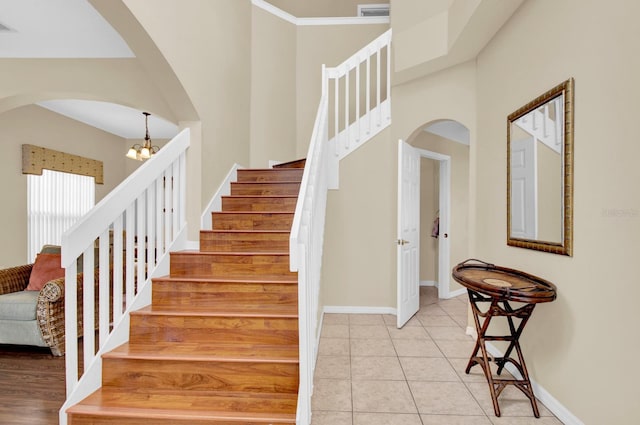 stairway with tile patterned flooring and a chandelier