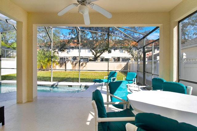 view of patio featuring ceiling fan, a fenced in pool, and glass enclosure