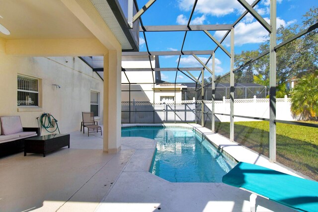 view of pool with a lawn, glass enclosure, a patio area, and an outdoor hangout area