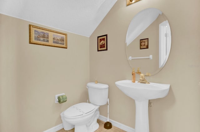 bathroom featuring toilet, tile patterned floors, a textured ceiling, and vaulted ceiling