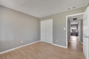 unfurnished bedroom featuring light wood-type flooring and a closet