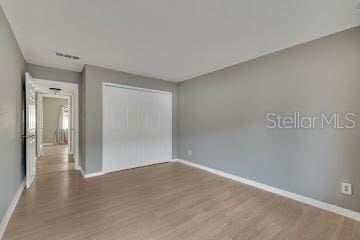 unfurnished bedroom with a closet and wood-type flooring