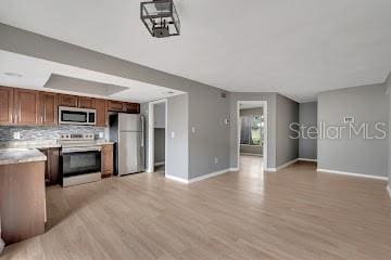 kitchen featuring decorative backsplash, stainless steel appliances, and light hardwood / wood-style flooring