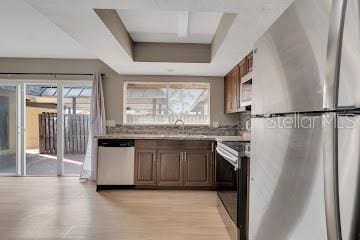 kitchen with light hardwood / wood-style floors, sink, stainless steel appliances, and a wealth of natural light