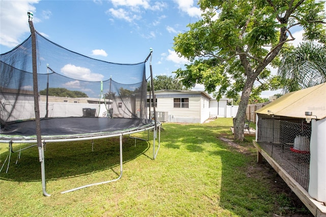 view of yard with a trampoline, cooling unit, and an outdoor structure