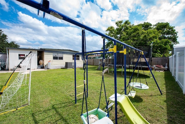 view of play area with a yard, cooling unit, a storage unit, and a trampoline