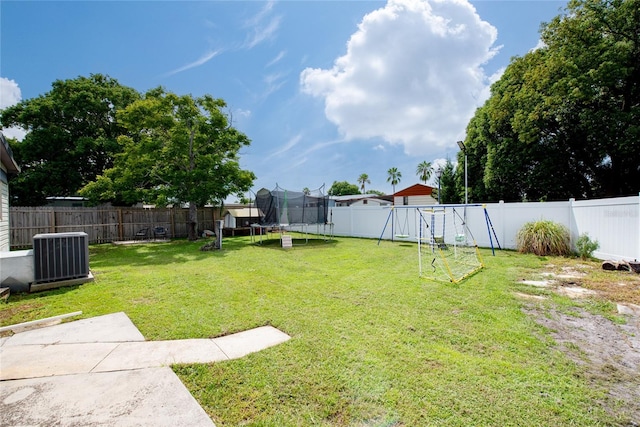 view of yard with central air condition unit, a playground, and a trampoline