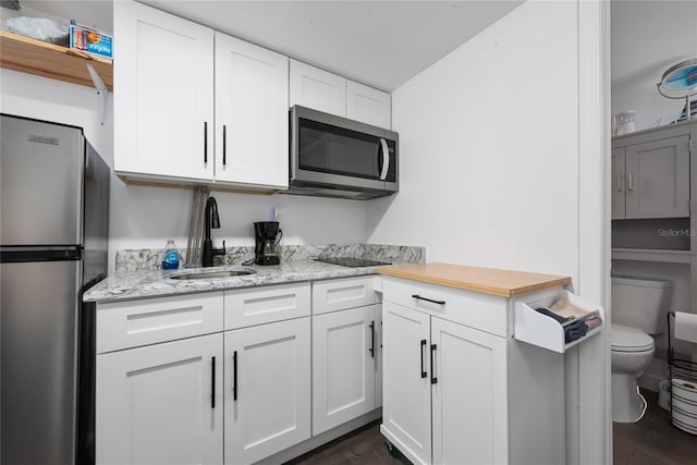 kitchen with dark hardwood / wood-style floors, sink, white cabinetry, and stainless steel appliances