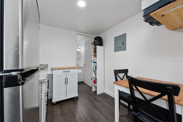 kitchen featuring electric panel, stainless steel fridge, white cabinets, and dark hardwood / wood-style floors