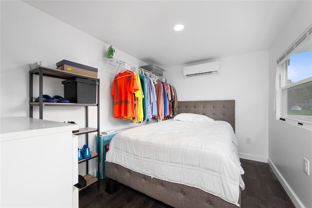 bedroom with dark hardwood / wood-style flooring and a wall mounted air conditioner