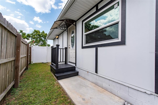 view of exterior entry with a yard