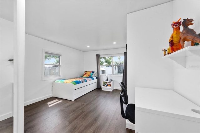 bedroom with dark hardwood / wood-style floors and multiple windows