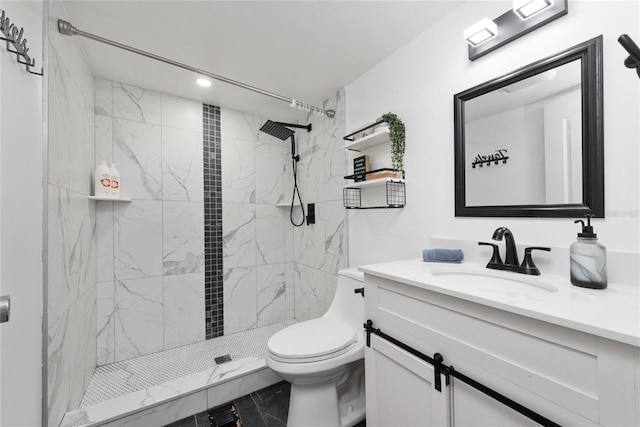 bathroom featuring a tile shower, vanity, and toilet